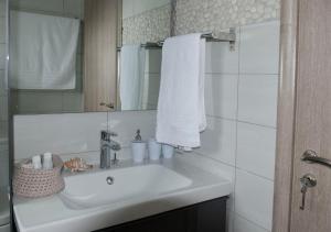 a white bathroom with a sink and a mirror at ILIOS H&E house in Elia Laconias +34 photos