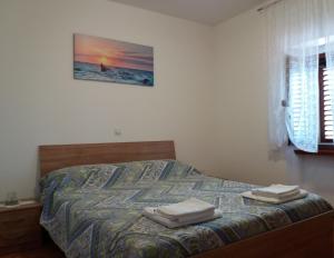 sypialnia z łóżkiem i dwoma ręcznikami na nim w obiekcie Apartmani Damiani w mieście Grožnjan