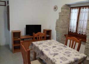 a dining room with a table and a television at Apartmani Damiani in Grožnjan