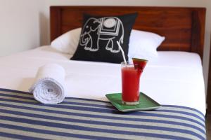 uma bebida numa bandeja verde numa cama em Amsterdam Tourist Rest em Anuradhapura