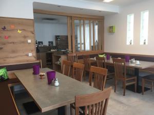 a dining room with wooden tables and chairs at Pension Anna in Rust