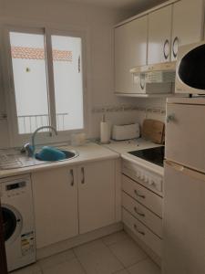 ラ・カラ・デ・ミハスにあるSeaview Apartment La Calaの白いキッチン(シンク、冷蔵庫付)