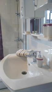 a white bathroom sink with a towel on it at MiA Apartmani Visoko in Visoko