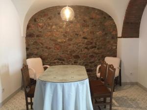 a table and chairs in a room with a brick wall at La Casa de las Tias in Villanueva de Córdoba