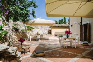 a patio with tables and chairs and umbrellas at Dimora Archimedea in Syracuse