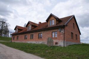 a large brick house on a grassy hill at Apartamenty Rodzinne in Wojciechy