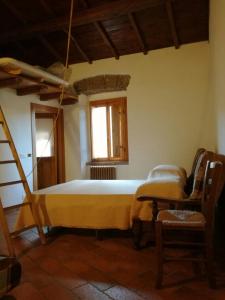 a bedroom with a bed and a ladder and a window at Casamatta a Blera in Blera
