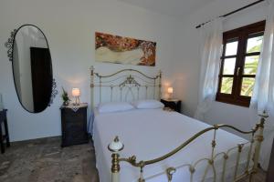 a bedroom with a white bed and a mirror at Haus Katerina in Vourvourou