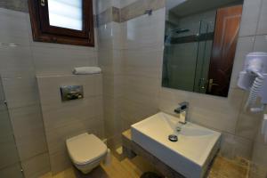 a bathroom with a white sink and a toilet at Haus Katerina in Vourvourou