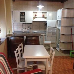 a kitchen with a table and chairs and a refrigerator at Eskolazaharra in Oronoz-Mugaire +6 photos