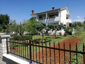 ein weißes Haus mit einem Zaun davor in der Unterkunft Apartment Vesna in Veleniki
