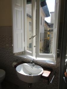 a white sink in a bathroom with a window at La Rondine in Lucca