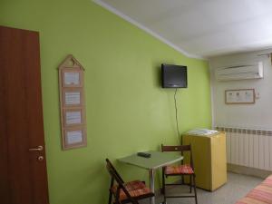 コティニョーラにあるAffittacamere Casadioの緑の壁の客室で、小さなテーブルが備わります。