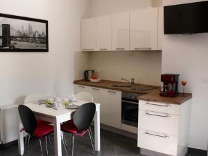 a small kitchen with a white table and chairs at Rogic Apartment in Lovran