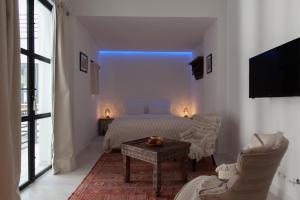 um quarto com uma cama, uma mesa e cadeiras em Riad Zebrakaro em Marrakech