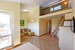 una sala de estar con una escalera de caracol en una casa en Vila Verbena, en Palanga
