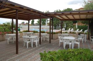 un patio con mesas y sillas bajo un pabellón en Hotel Perla, en Senigallia