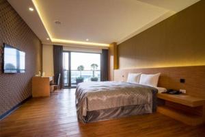 Cette chambre comprend un lit et une grande fenêtre. dans l'établissement Ai Ni Ya Motel, à Beigang