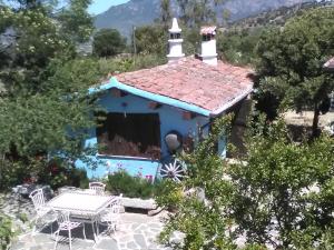 una pequeña capilla con una mesa y sillas frente a ella en Camisadu, en Oliena