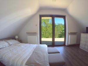um quarto com uma cama e uma grande janela em Przystan Kurpiowska em Turośl