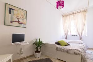 Televízia a/alebo spoločenská miestnosť v ubytovaní Maison Ortigia