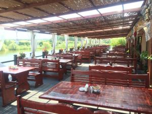 un restaurante con mesas y sillas de madera y un río en Lacul Racilor, en Olimp