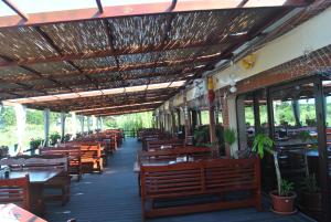 a restaurant with wooden tables and chairs and a roof at Lacul Racilor in Olimp