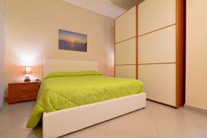 1 dormitorio con 1 cama con edredón verde en Case Panoramiche sul Lago, en Messina