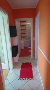 a bathroom with orange walls and a red rug at Apartment Vladka Koper in Koper