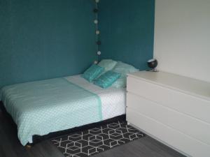 - une petite chambre avec un lit et un mur vert dans l'établissement Studio Beaulieu, à Rennes