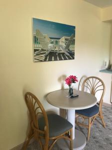 una mesa y sillas con un jarrón de flores. en Cape Harbor Motor Inn en Cape May