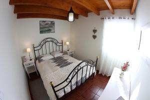 a bedroom with a metal bed in a room at Casa da Rainha Bungallow in Estreito da Calheta +34 photos