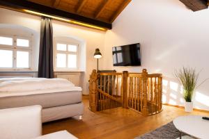 ein Schlafzimmer mit einem Bett und einem Fernseher an der Wand in der Unterkunft KulturQuartier in Regensburg