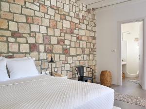 a bedroom with a bed and a brick wall at Studio Vipera in Triovasálos
