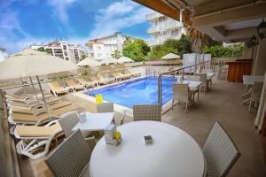 a patio with tables and chairs and a swimming pool at City Hotel Marmaris in Marmaris
