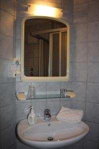 a bathroom with a sink and a mirror and towels at Hotel Blume Post in Albstadt