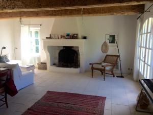 sala de estar con chimenea y silla en Les Amarines, en Saint-Rémy-de-Provence