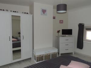 a bedroom with a large white cabinet and a mirror at Ilot Bonheur in Ury