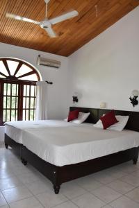a large bed in a room with a ceiling at Sethra Villa Bentota in Bentota