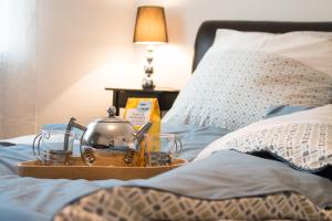 a tea kettle on a tray on a bed at Dein Hyggelig-Haus in Elz