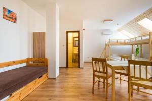 a room with a bed and a table and chairs at Brigadéros Vendégház in Siklós