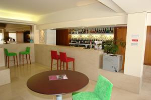 a bar with red and green chairs and a table at Hotel Eurosol Leiria & Jardim in Leiria