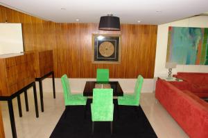 a living room with a table and green chairs at Hotel Eurosol Leiria & Jardim in Leiria
