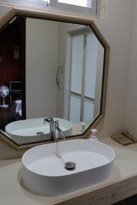 a bathroom sink with a large mirror above it at Guest House Miyakojima in Miyako-jima