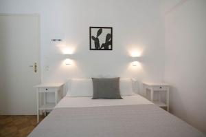 a bedroom with a white bed with two night stands at Avra Pension in Ios Chora