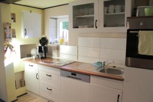 a kitchen with white cabinets and a sink at Apartment am Bieleboh in Beiersdorf