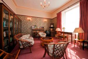 a living room with chairs and a table and a window at Ashurst Lodge in Torquay