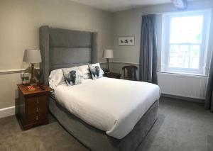 Un dormitorio con una gran cama blanca y una ventana en The Bulls Head, en Swadlincote