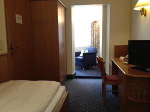 a hotel room with a bed and a desk and a chair at Hohenzollern in Bad Neuenahr-Ahrweiler