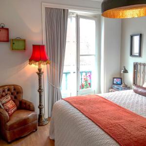 een slaapkamer met een bed, een lamp en een stoel bij Unique Design Apartments in Lissabon